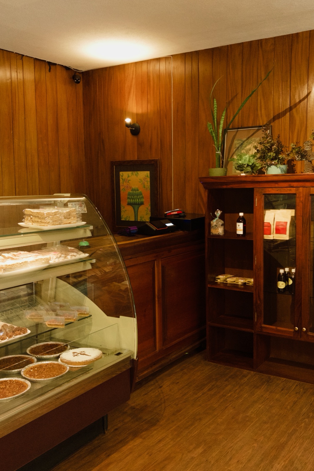 Interior de la tienda Friandise con vitrina de postres y paredes de madera